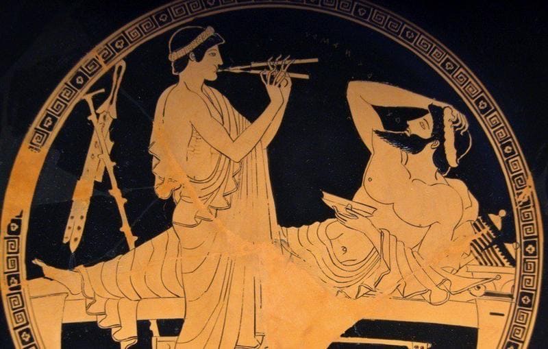 Two Greek men with one playing the flute