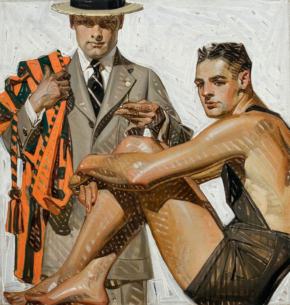 Two young men, one standing, one sitting in a bathing suit