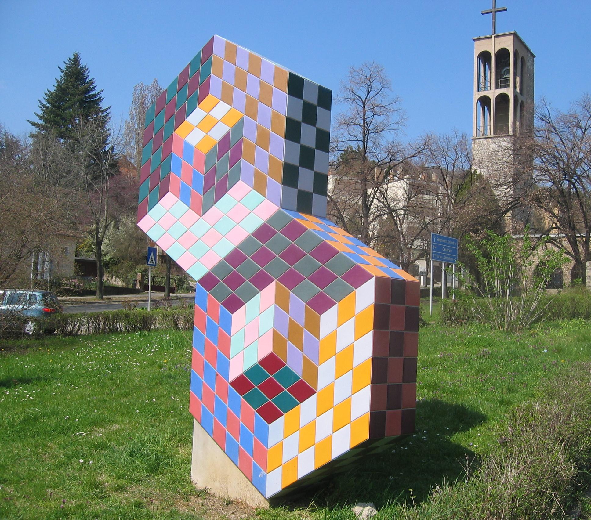 Sculpture made of cubes, covered with a colorful checkerboard pattern 