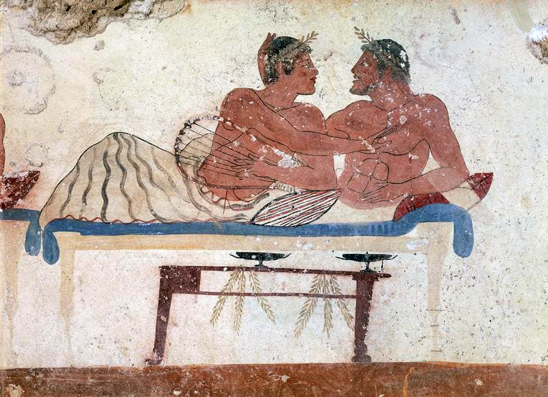 Two Greek men embracing on a canapé